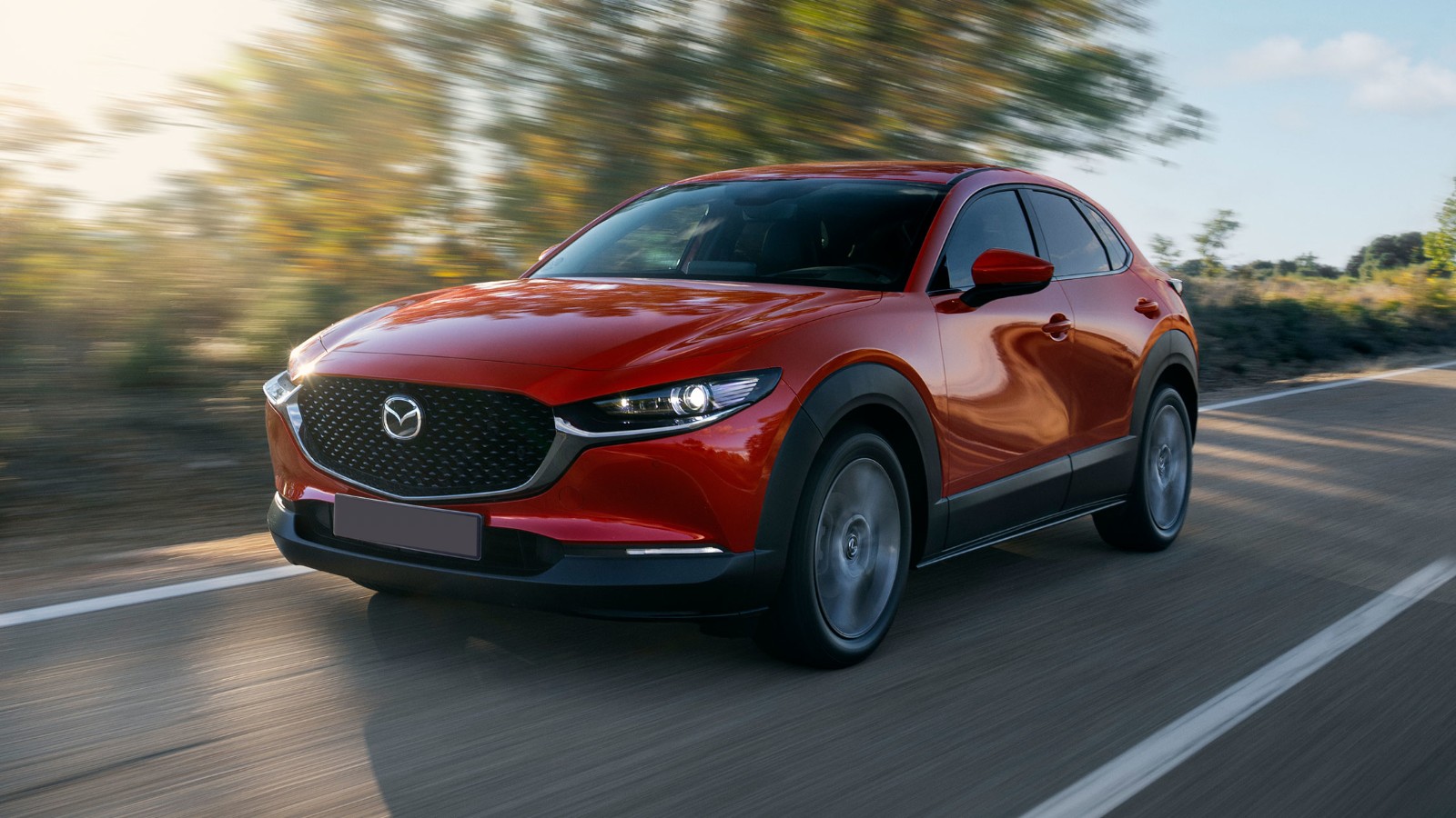 Red Mazda CX-30 driving on an open road (official Mazda Ireland image)
