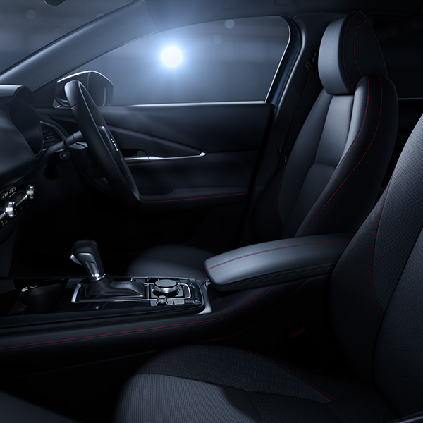 Mazda CX-30 interior with right-hand drive, front seats, steering wheel and centre console